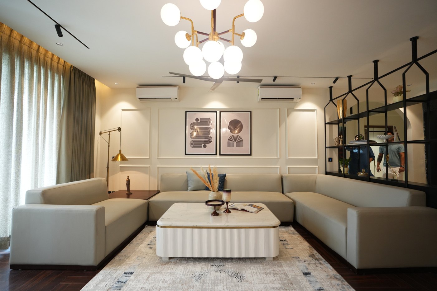Contemporary living room with a deep blue sofa, bespoke panelling and layered lighting in an independent floor in Gurgaon