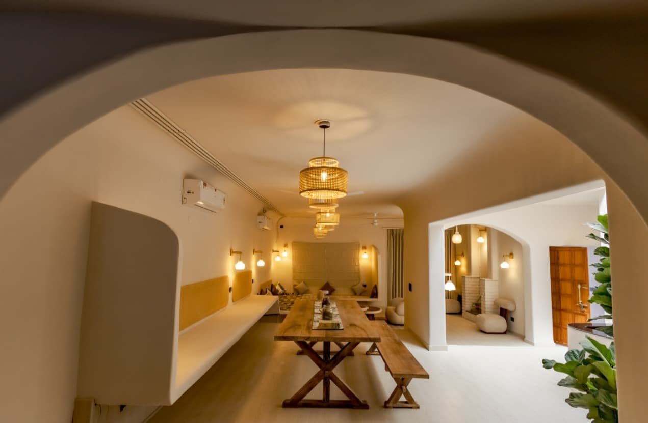 Arched lounge and dining area with rattan pendant lighting in a Spaces by Raag interior
